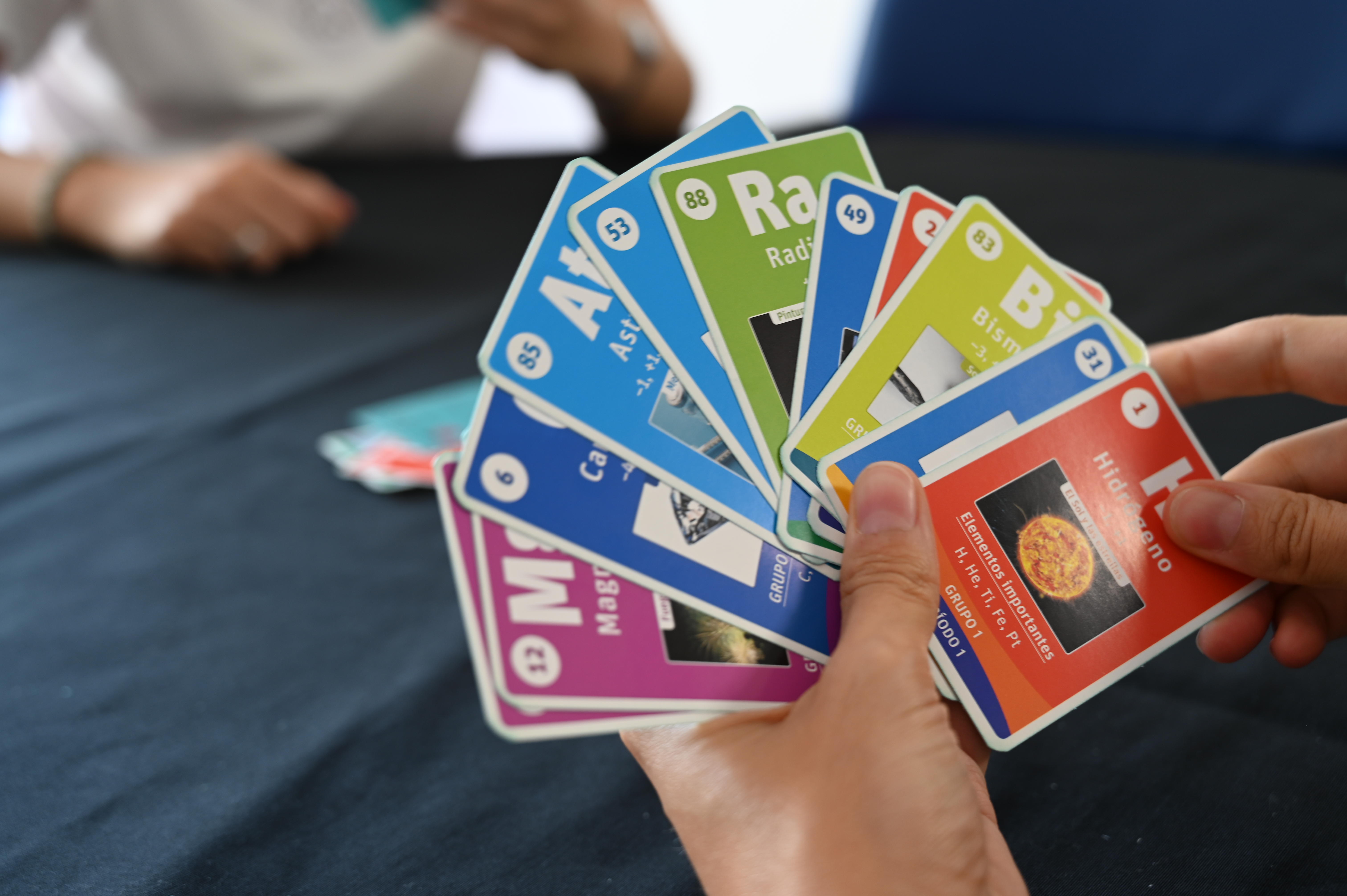 cartas de la baraja del UNO químico en una mano