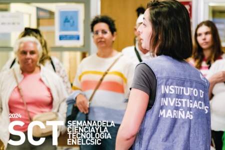 Una trabajadora del instituto de investigacións Mariñas, comeza unha visita guiada ao centro coas persoas visitantes de fondo.
